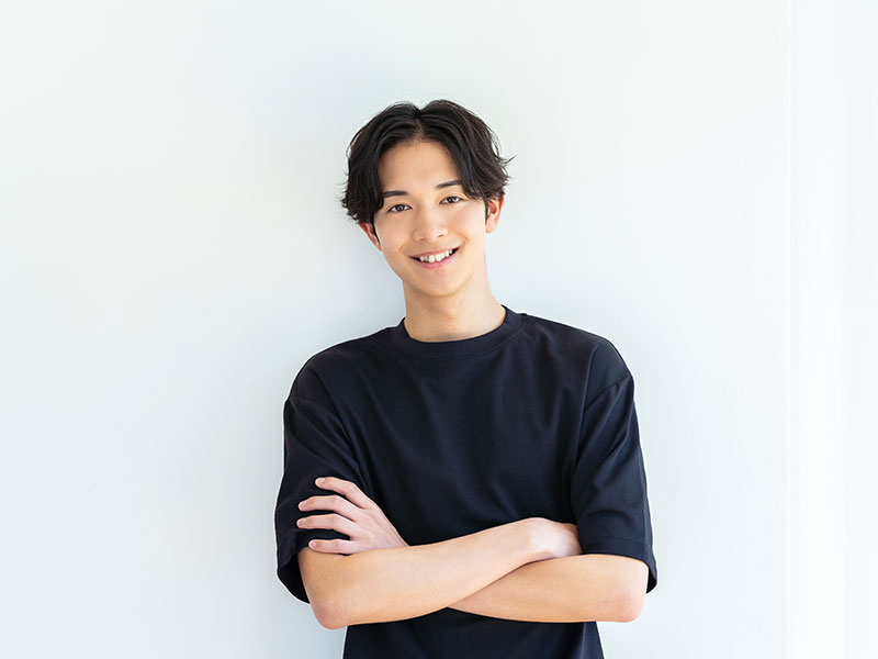 白壁で腕を組む